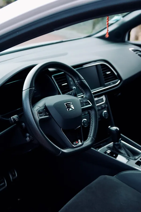 Volante y acabados del interior de un automóvil; fotografía de referencia.